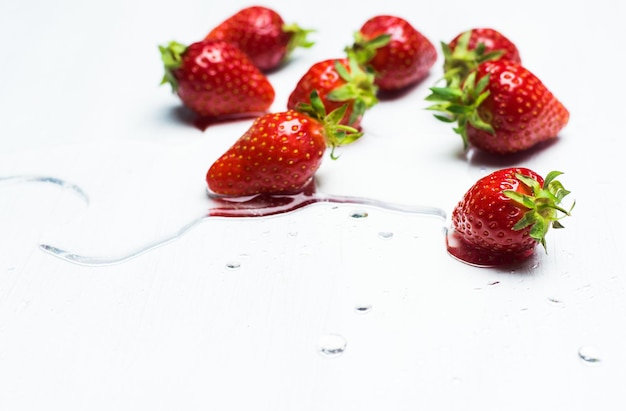 Hooghoekbeeld van aardbeien op tafel tegen een witte achtergrond