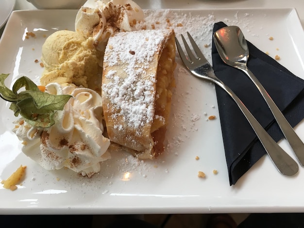 Foto hooghoekbeeld van appelstrudel geserveerd met ijs op bord