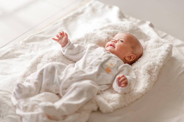 Hooghoekbeeld van baby jongen die thuis op bed ligt
