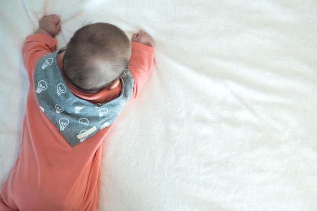 Foto hooghoekbeeld van baby meisje dat thuis op bed ligt