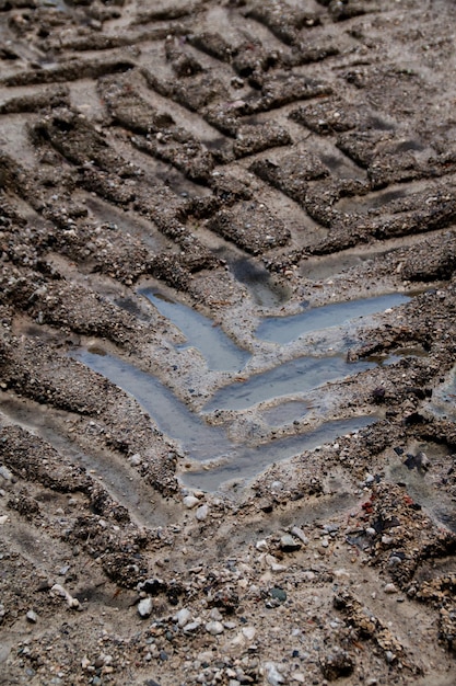 Foto hooghoekbeeld van bandensporen op modderige weg