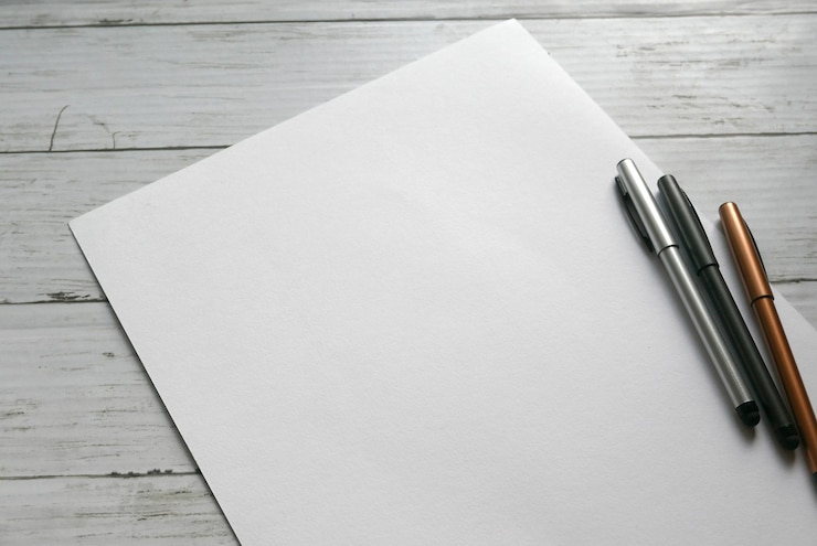 Foto hooghoekbeeld van blank papier en pennen op tafel