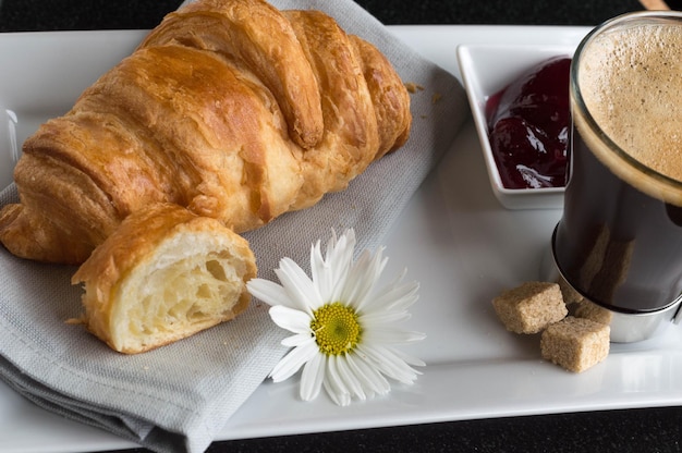 Hooghoekbeeld van brood met conserven en zwarte koffie op tafel