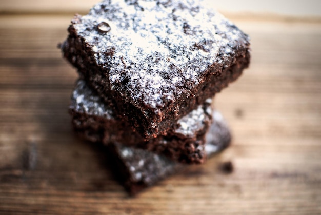 Hooghoekbeeld van chocoladecaramelbrownie met suikerpoeder op tafel