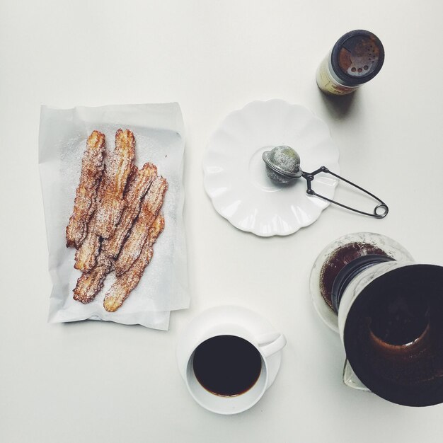 Hooghoekbeeld van churros en koffiekop op tafel