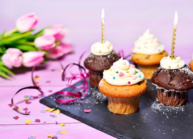 Hooghoekbeeld van cupcakes met bloemen op tafel