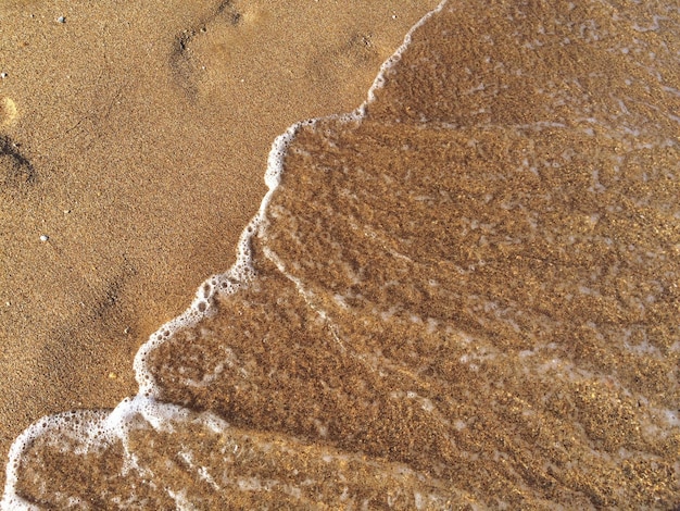 Hooghoekbeeld van de golf op het strand