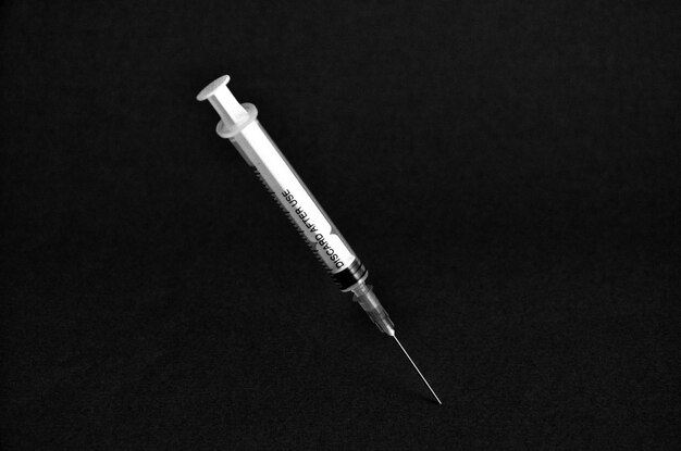 Foto hooghoekbeeld van de injectiespuit op zwarte achtergrond