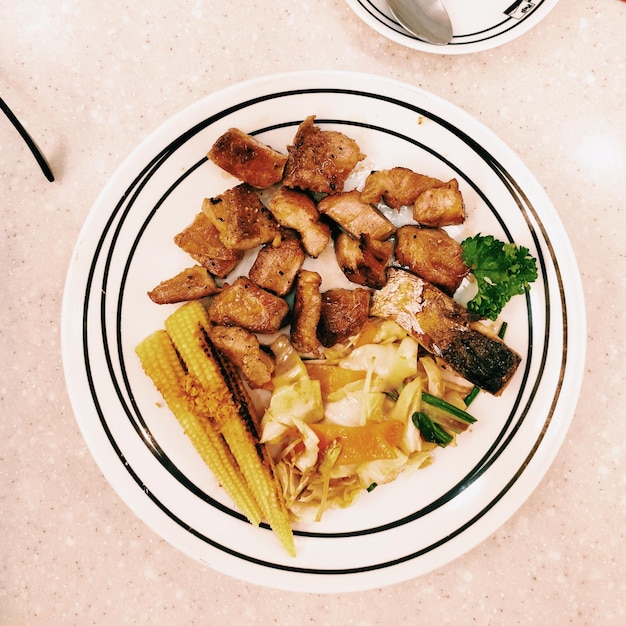 Foto hooghoekbeeld van de maaltijd die op het bord wordt geserveerd