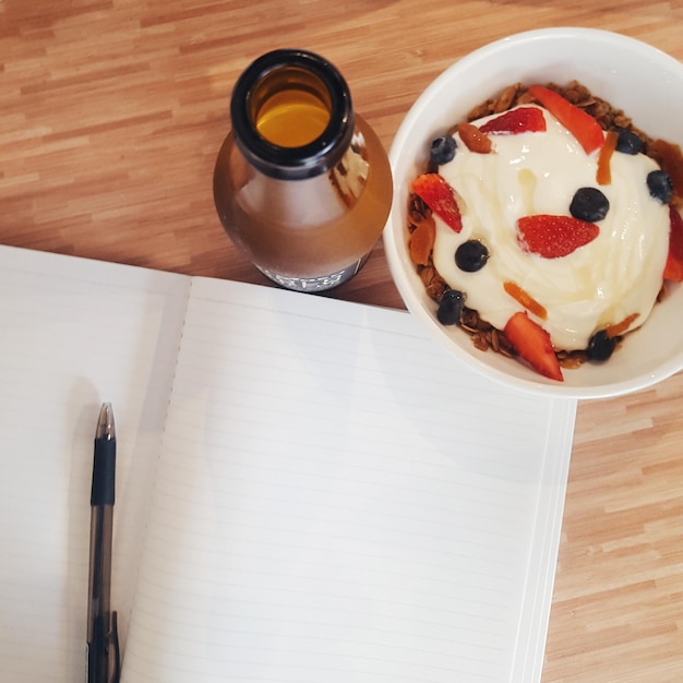 Hooghoekbeeld van dessert en drankje met een leeg boek op tafel.
