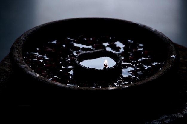 Foto hooghoekbeeld van diya met rozenblaadjes die op het water drijven