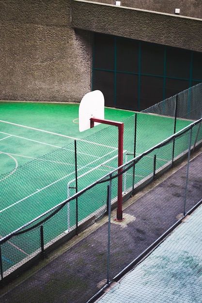 Hooghoekbeeld van een basketbalhoepel door een hek