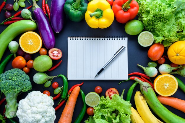 Hooghoekbeeld van een boek met fruit en groenten op tafel