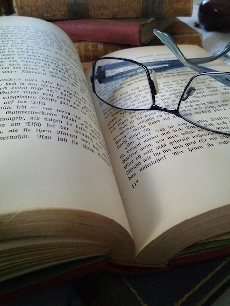 Hooghoekbeeld van een bril op een open boek aan tafel