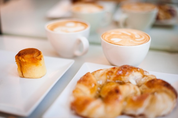 Hooghoekbeeld van een dessert met cappuccino's en croissants op tafel