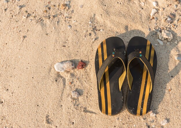 Foto hooghoekbeeld van een flip-flop op het zand op het strand