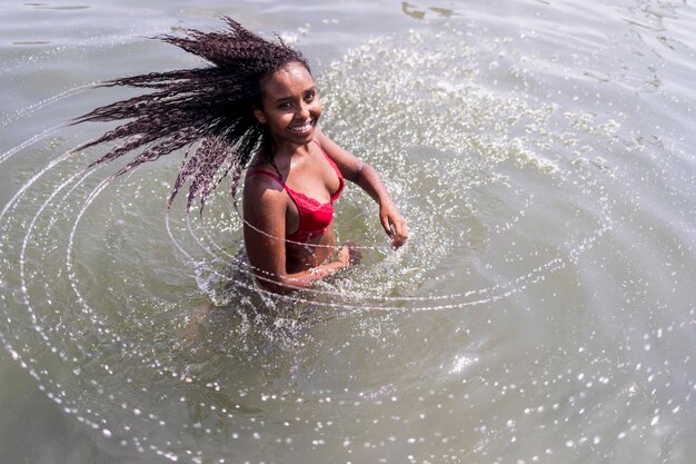 Foto hooghoekbeeld van een jonge vrouw die in de zee staat