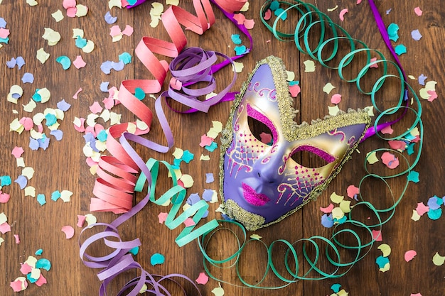 Hooghoekbeeld van een kleurrijk masker met decoraties op een houten tafel