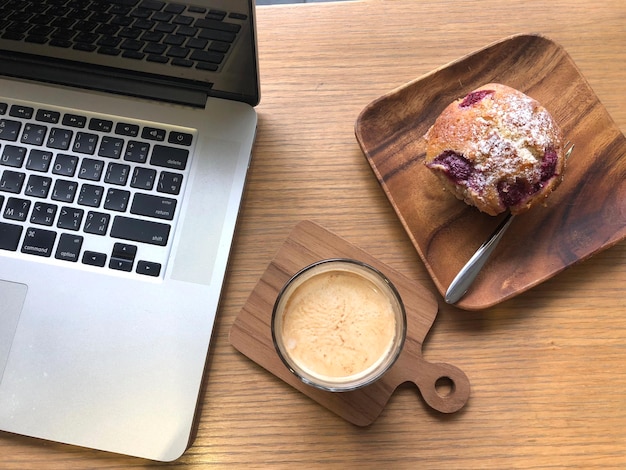 Hooghoekbeeld van een koffiekop met een laptop op tafel