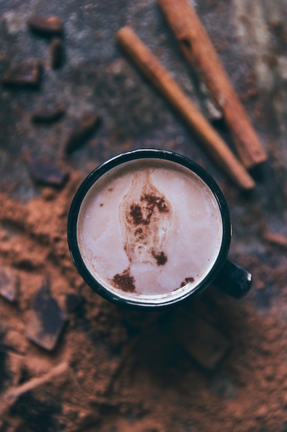 Hooghoekbeeld van een koffiekop met kaneel op tafel