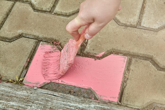 Foto hooghoekbeeld van een man die een asfaltsteen op straat schildert