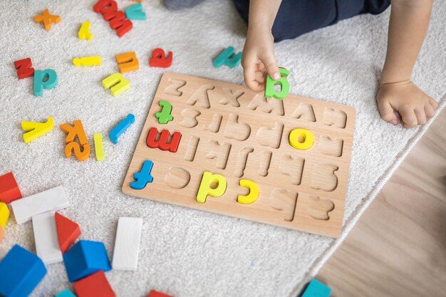 Foto hooghoekbeeld van een man die met speelgoedblokken op tafel speelt