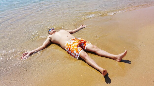 Foto hooghoekbeeld van een man die op het strand ligt