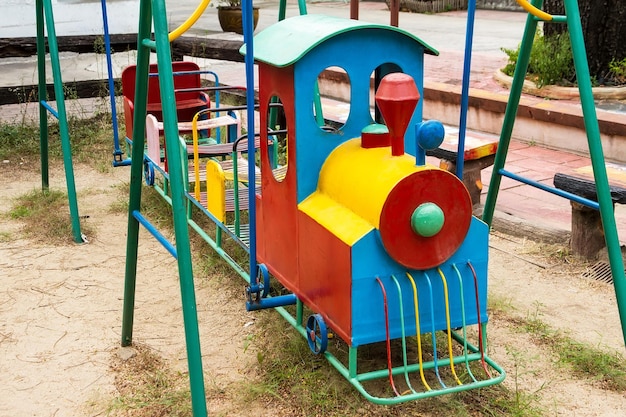 Hooghoekbeeld van een metalen speelgoedtrein op een speeltuin in een openbaar park