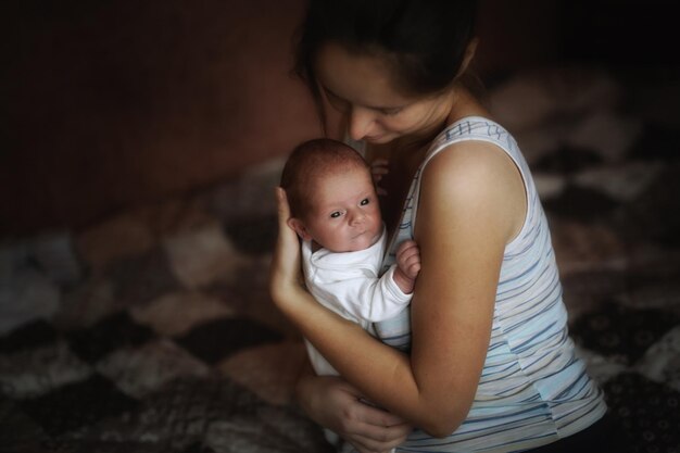 Foto hooghoekbeeld van een schattige jongen die thuis met zijn moeder op bed ligt