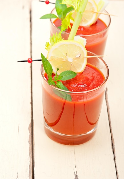 Hooghoekbeeld van een verse rode smoothie met citroensnijden die op tafel wordt geserveerd
