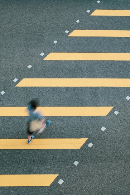 Hooghoekbeeld van een vrouw die de weg oversteekt in de stad