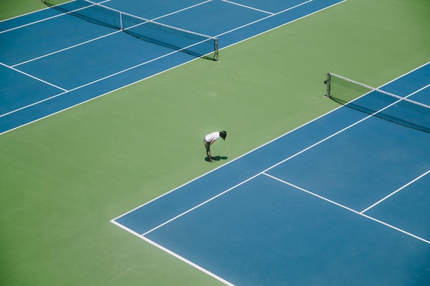 Hooghoekbeeld van een vrouw die in een tennisbaan staat