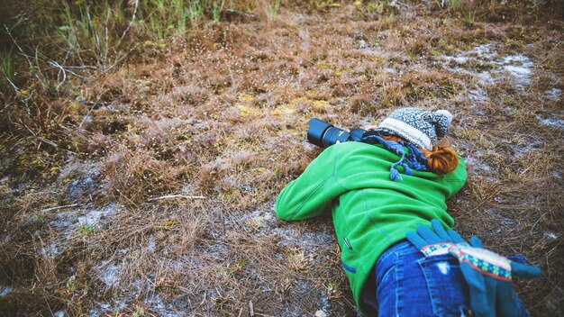 Hooghoekbeeld van een vrouw die gras op het land fotografeert