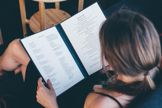 Foto hooghoekbeeld van een vrouw die het menu leest in een restaurant