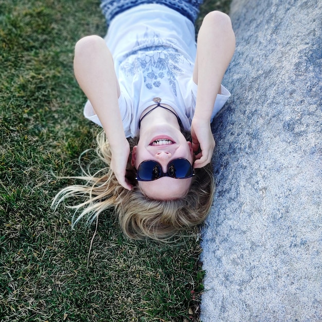 Foto hooghoekbeeld van een vrouw die op het gras ligt