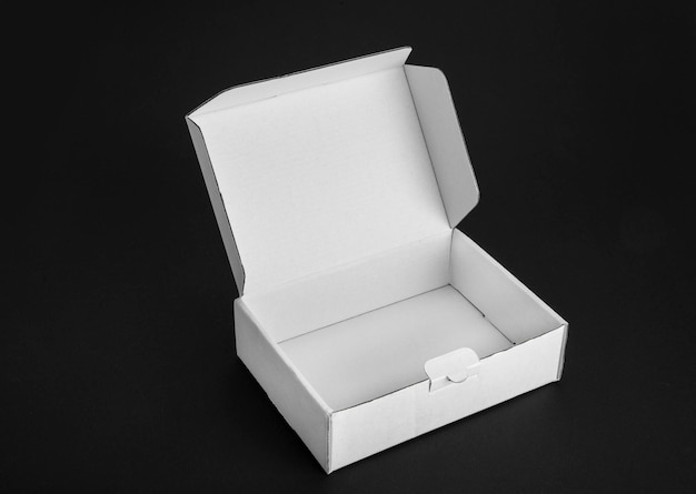 Hooghoekbeeld van een witte doos op tafel tegen een zwarte achtergrond