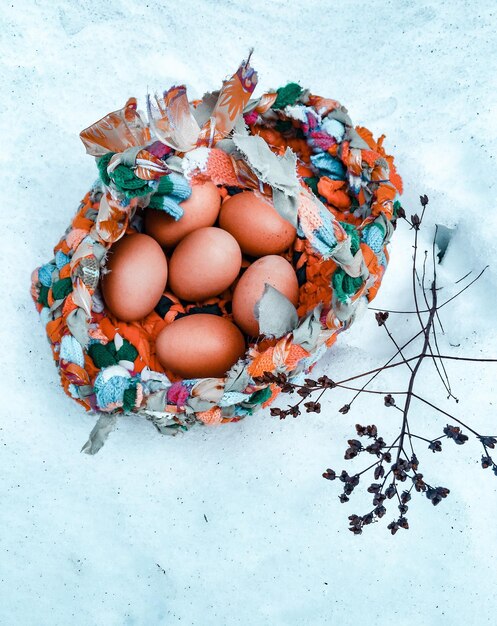 Hooghoekbeeld van eieren in een lapmand op sneeuw