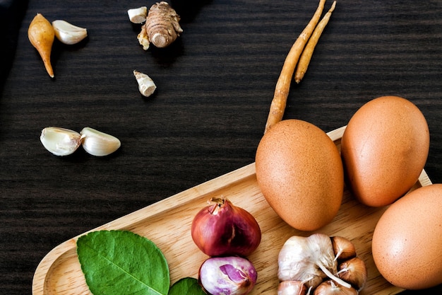 Hooghoekbeeld van eieren met specerijen en groenten op een houten tafel