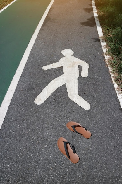 Hooghoekbeeld van flip-flops op het voetpad