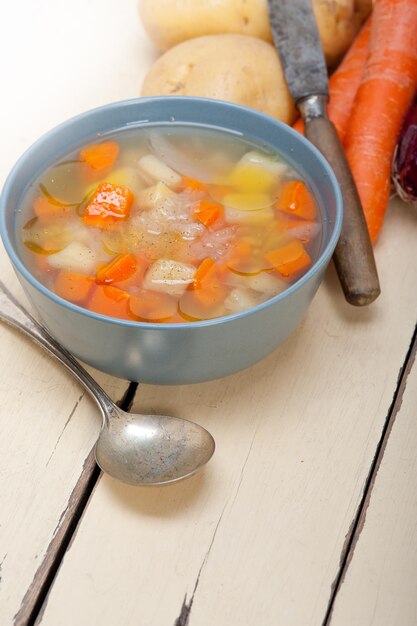 Foto hooghoekbeeld van gehakte wortels en aardappelen in een schaal op tafel