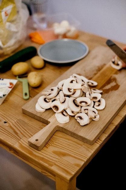 Foto hooghoekbeeld van gesneden witte paddenstoelen op een houten snijplank