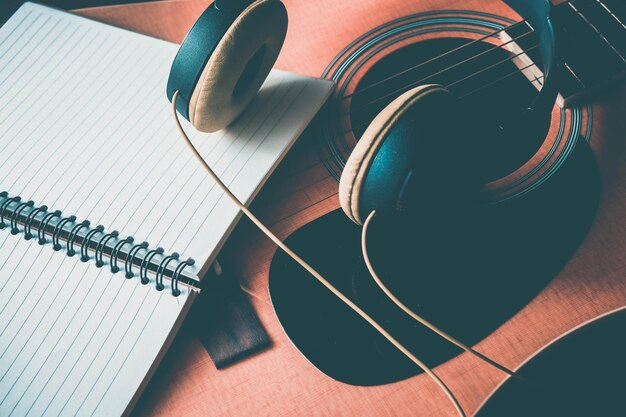 Foto hooghoekbeeld van gitaar met koptelefoon en boek