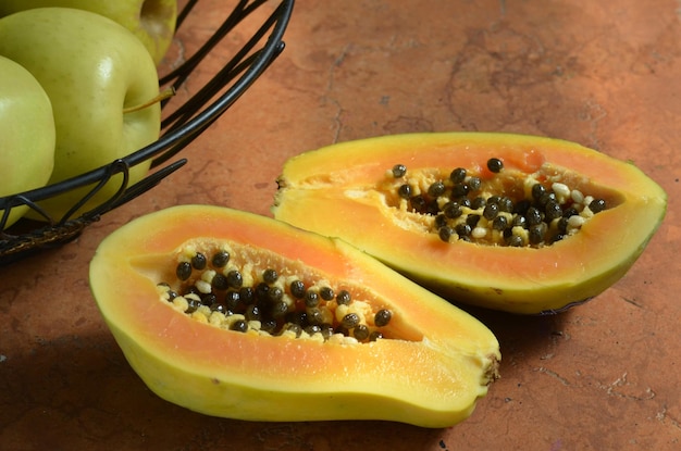 Hooghoekbeeld van Granny Smith appels en papaya op tafel