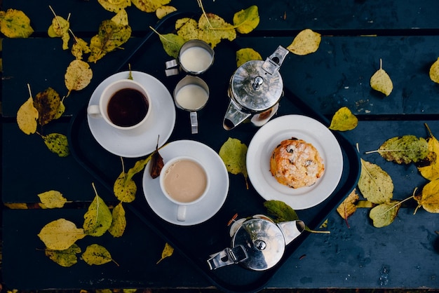 Foto hooghoekbeeld van herfstbladeren bij ontbijt in een dienblad op tafel