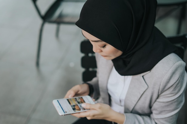 Hooghoekbeeld van jonge vrouw met mobiele telefoon