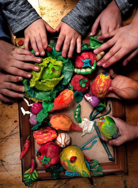 Foto hooghoekbeeld van kinderen met handen die modelleer klei hebben