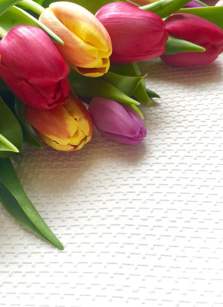 Foto hooghoekbeeld van kleurrijke tulpen op tafeldoek
