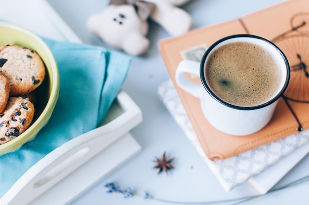 Hooghoekbeeld van koffie met boeken en koekjes op tafel