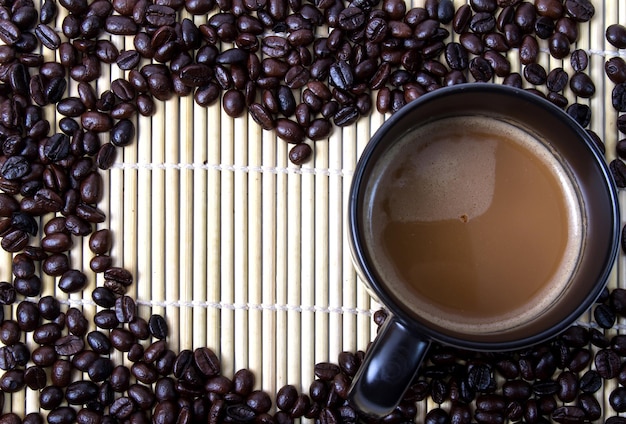 Foto hooghoekbeeld van koffie met geroosterde bonen op tafel