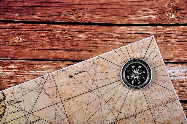 Foto hooghoekbeeld van kompas en kaarten op tafel